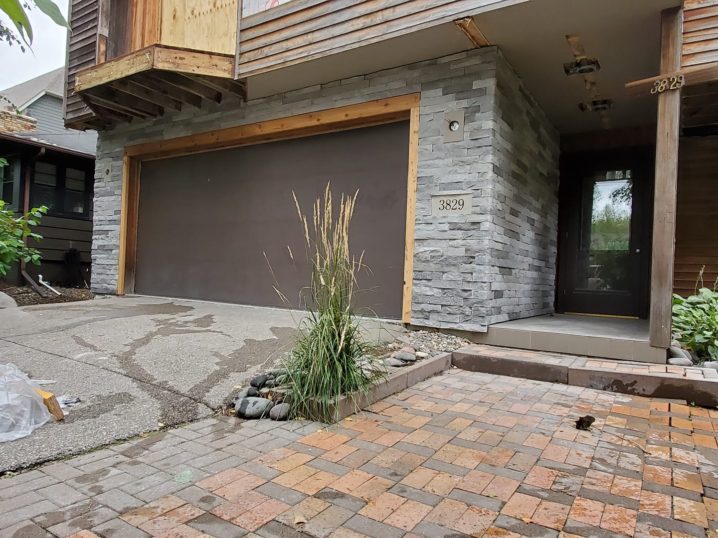 Pale stacked stone framing a residential garage and front entrance
