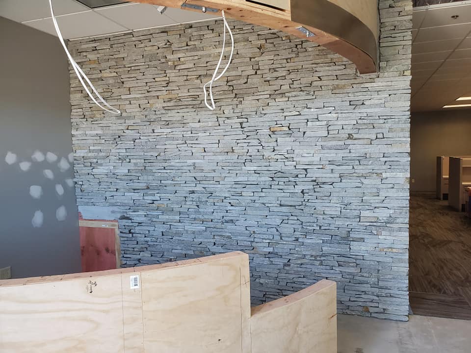 A detailed stacked-stone interior feature wall during construction