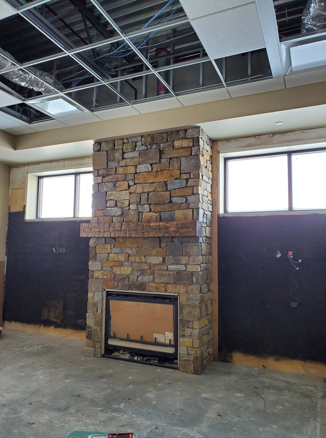 Stone fireplace and timber mantel during an interior construction project